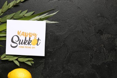 Four species (lulav, hadas, arava, etrog) and greeting card with text HAPPY SUKKOT on black grunge background clipart