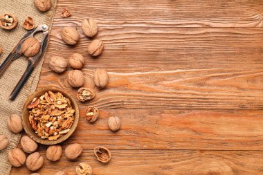 Ahşap arka planda ceviz ve fındıkkıran ile kase