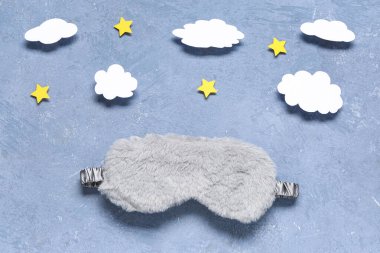 Renkli arka planda uyku maskesi, kağıt bulutlar ve yıldızlar ile yaratıcı bileşim
