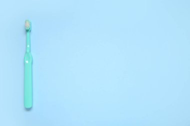 Renkli arkaplanda mavi plastik diş fırçası.