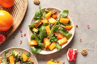 Bir tabak lezzetli salata, hurma, nar tohumu ve arka planda ceviz.