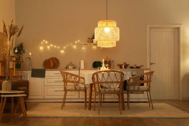 Parlayan lambalar, masa ve akşamları beyaz tezgahlı modern mutfak.