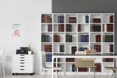 Masası ve kitaplığı olan bir tıp bürosu.