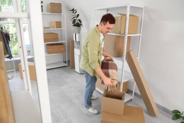 Erkek gönüllü, merkezdeki bağış kutusuna ekose koyuyor.