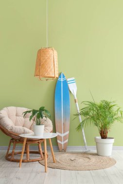 Oturma odasının içinde sörf tahtası, kürek ve koltuk var.