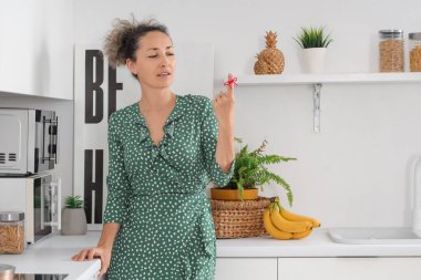 Mutfakta parmağında kırmızı bir iple düşünceli orta yaşlı bir kadın. Hatırlatma konsepti