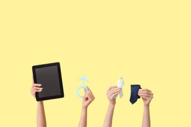 Tablet bilgisayarı olan kadın eller, erkek işareti, açık mavi kurdele ve sarı arka planda kravat. Prostat kanseri kavramı