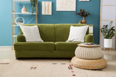 İçinde resimler ve yeşil kanepe olan şık bir oturma odası.