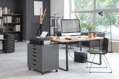 Çalışma yeri, modern bilgisayar ve sandalyeli şık bir ofis.