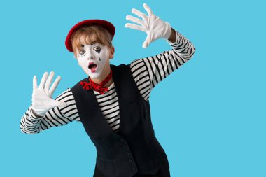 Mavi arka planda kadın pandomimist