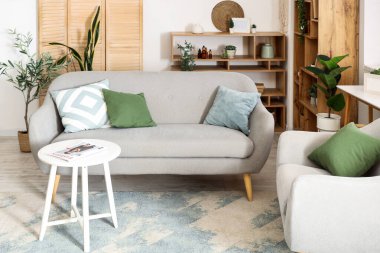 Ahşap perdeli, kanepeli ve koltuklu oturma odasının içi.