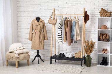 Sonbahar giysileri ve aksesuarlarıyla modern giyinme odasının içinde.