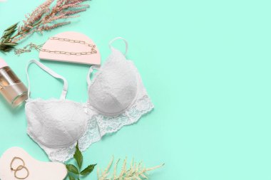 Dantelli kadın sütyeni, aksesuarlar ve çiçeklerle renk arkaplanı