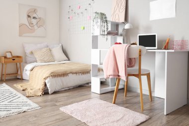 Yatağı ve çalışma masası olan bir gencin odası.