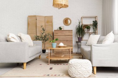 Ayna, gri kanepeler ve çekmeceleri olan oturma odasının içinde.