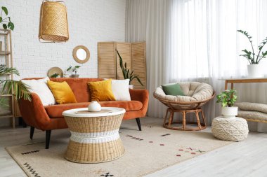 Oturma odasının içinde ayna, kırmızı kanepe ve bitkiler var.