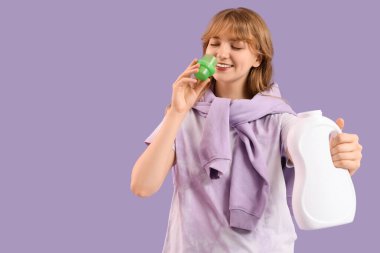 Leylak arka planında çamaşır deterjanı kokusu alan genç bir kadın.