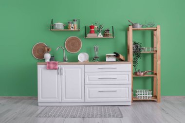 Mutfağın içinde tezgahlar, raflar ve çatallar var.