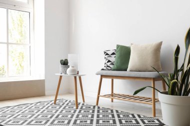 Yumuşak bank, masa ve bitkilerle aydınlatma odasının içi