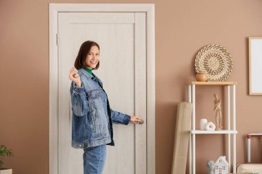 Taşındığı gün salonun kapısını açan anahtarı olan genç bir kadın.