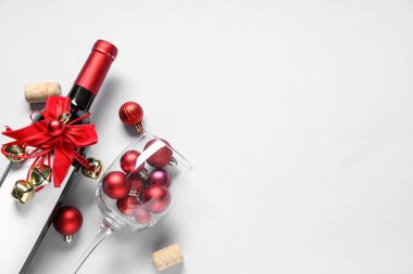 Beyaz arka planda Noel süsleri olan bir şişe şarap.