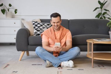 Evde cep telefonu olan bir adam.