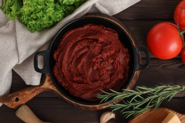 Taze domates ezmesi ve koyu ahşap arka planda farklı malzemelerle kompozisyon.