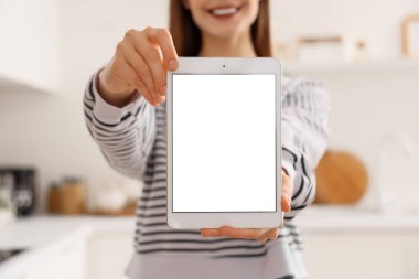 Mutfakta boş tablet bilgisayarı olan genç bir kadın, yakın plan.