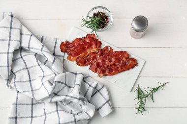 Kızarmış pastırmalı pastırma, biberiye ve beyaz ahşap arka planda bir kase biberli mısır.