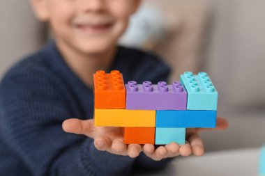 Evinde renkli tuğlaları olan mutlu küçük çocuk, yakın plan.
