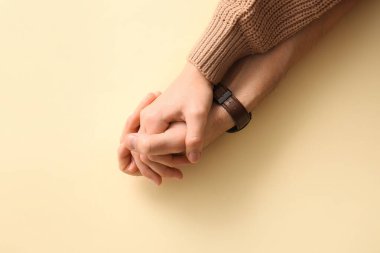 Bej arka planda el ele tutuşan çift, üst görünüm