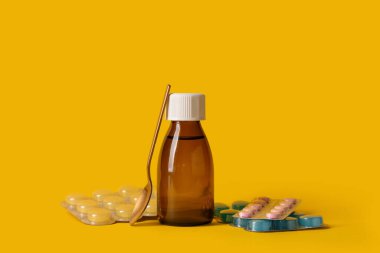 Bottle of cough syrup with spoon and different pills on yellow background clipart