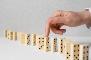 Beyaz arka planda kadın el ve sıra domino taşları
