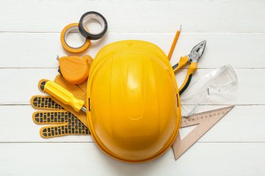 Marangoz aletleri ve beyaz ahşap arka planda kalın başlık