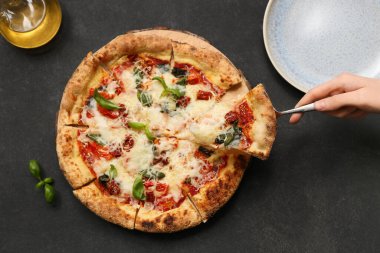 Koyu arkaplanda lezzetli bir pizza dilimi alıyorum.