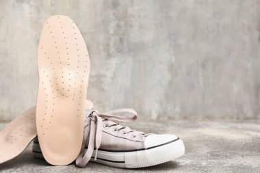 Gri grunge arka planda ortopedik tabanlı ayakkabı.