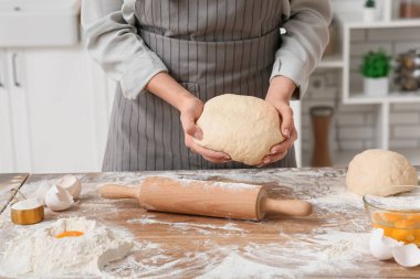 Mutfakta taze hamur yoğuran bir kadın