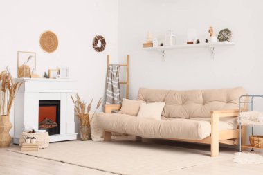 Şömineli, kanepeli ve kış dekorlu oturma odasının içi aydınlık.