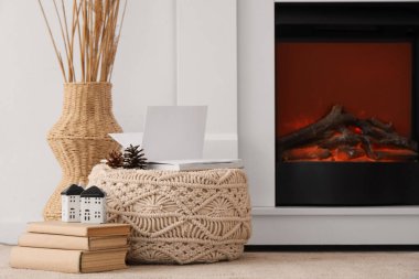 Şöminenin yanında kitapları olan bir puf.