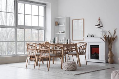 Odanın içinde yemek masası, şömine ve kış dekoru var.