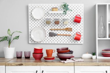 Tabaklar ve kaseler mutfaktaki beyaz duvarın yanında.