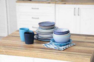 Mutfaktaki ahşap masada farklı tabaklar, kaseler ve fincanlar.