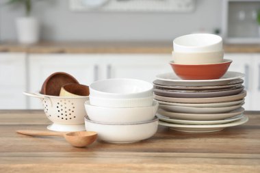 Mutfaktaki ahşap masada farklı tabak ve kaseler.