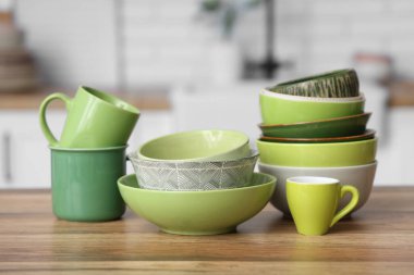 Mutfaktaki ahşap masada çanaklar ve fincanlar.