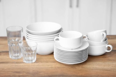 Mutfaktaki ahşap masada yığınla tabak ve bardak.