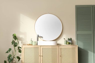 Çekmeceler ve katlanır ekran. Banyoda bej duvarın yanında.