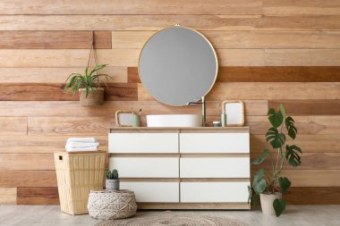 Lavabo ve banyo malzemeleriyle dolu sandık banyoda ahşap duvarın yanında.