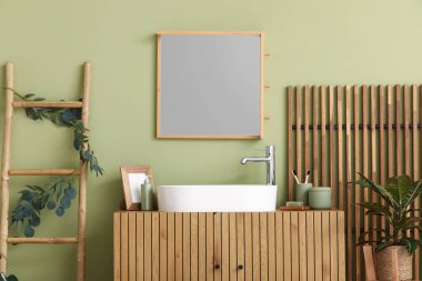 Göğüs, merdiven ve katlanır ekran. Banyonun içindeki yeşil duvarın yanında.