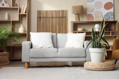 Kanepe, puf ve çiçekli rahat bir oturma odası.