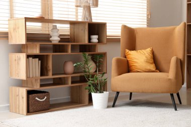 Kahverengi koltuk ve raflar oturma odasının iç tarafında.